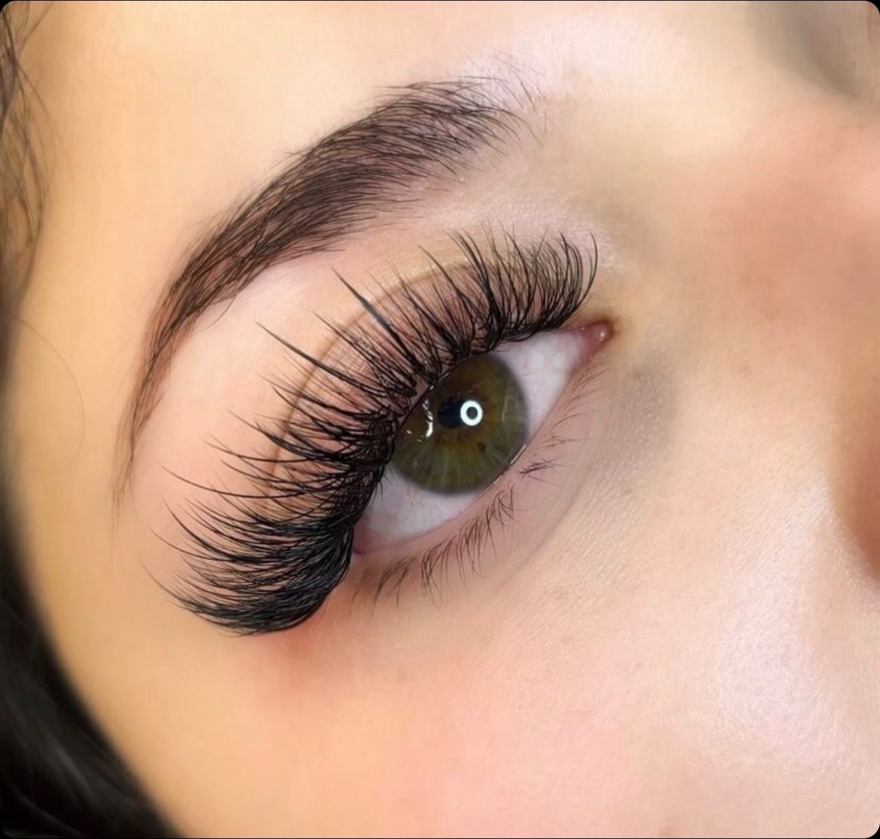 Full lash extensions on a green eye, close-up